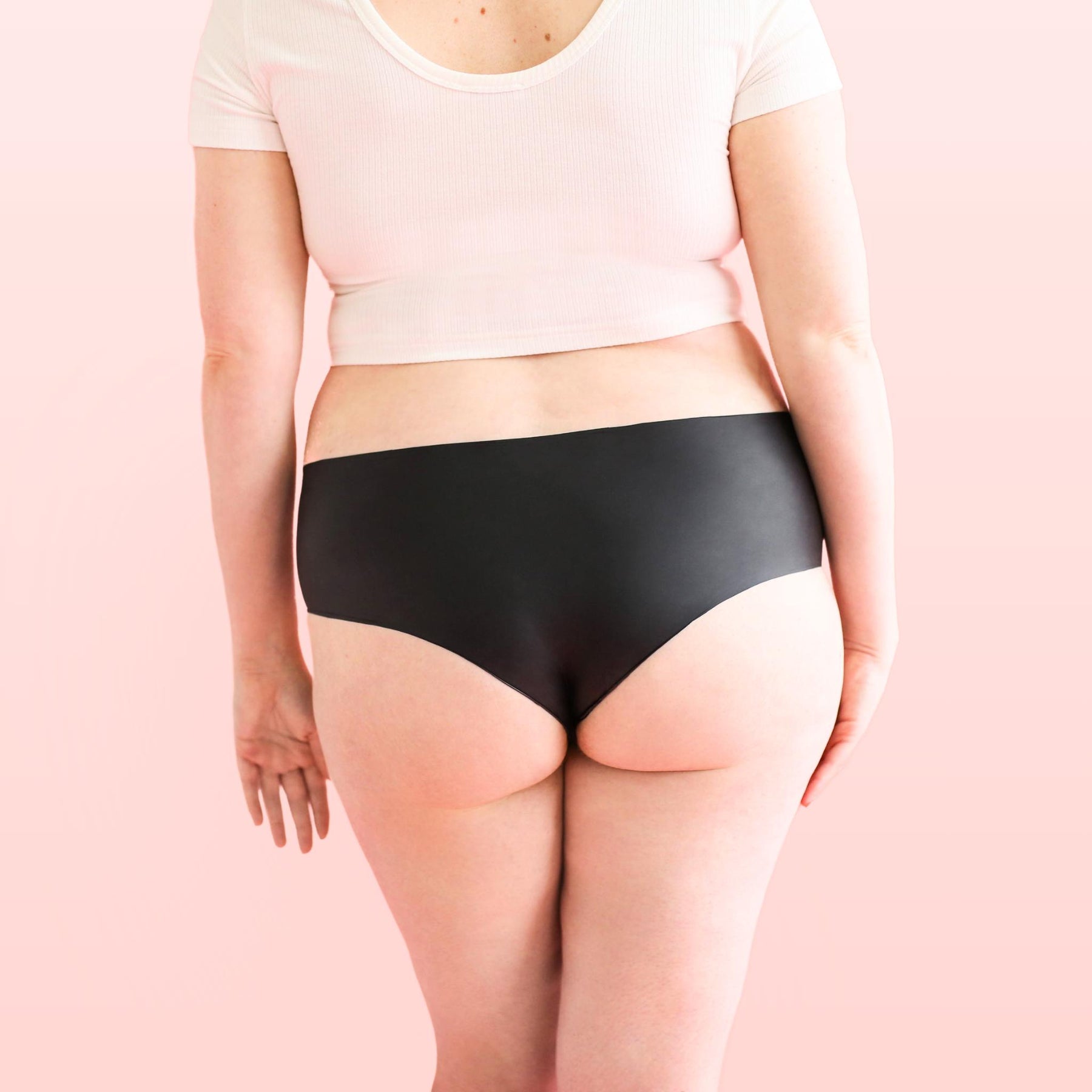 Lorals model Amanda demonstrates the back view of Black Latex Panties in Shortie Style