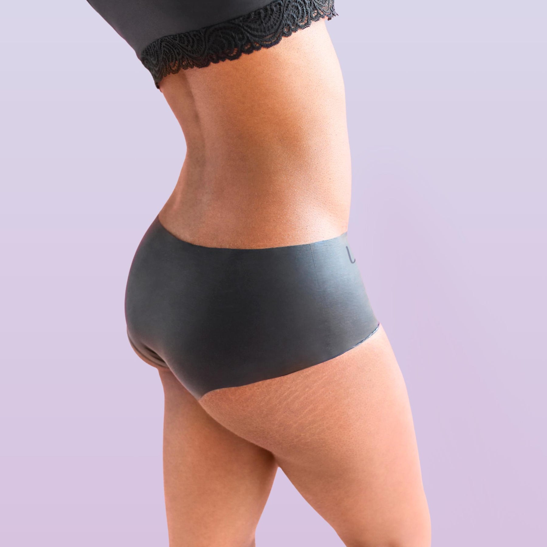 Lorals model Gladys demonstrates the side view of Black Latex STI Protection Panties in Shortie Style
