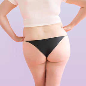 Lorals model Amanda demonstrates the back view of Black Latex STI Protection Panties in Bikini Style