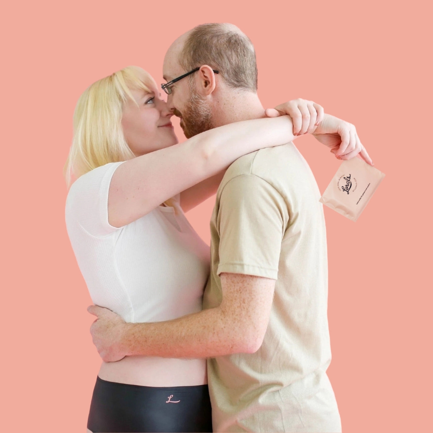 A man and a woman kiss and hold Lorals Undies for Comfort during oral