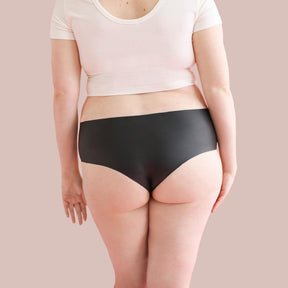 Lorals model Amanda demonstrates the back view of Black Latex Panties in Shortie Style